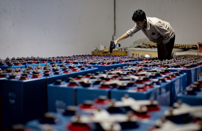 Worker inspecting industrial battery systems