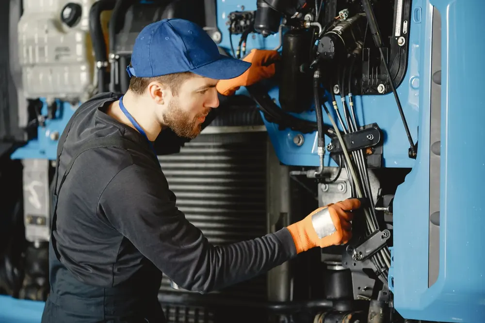 Technician checking hydraulic hoses on industrial equipment
